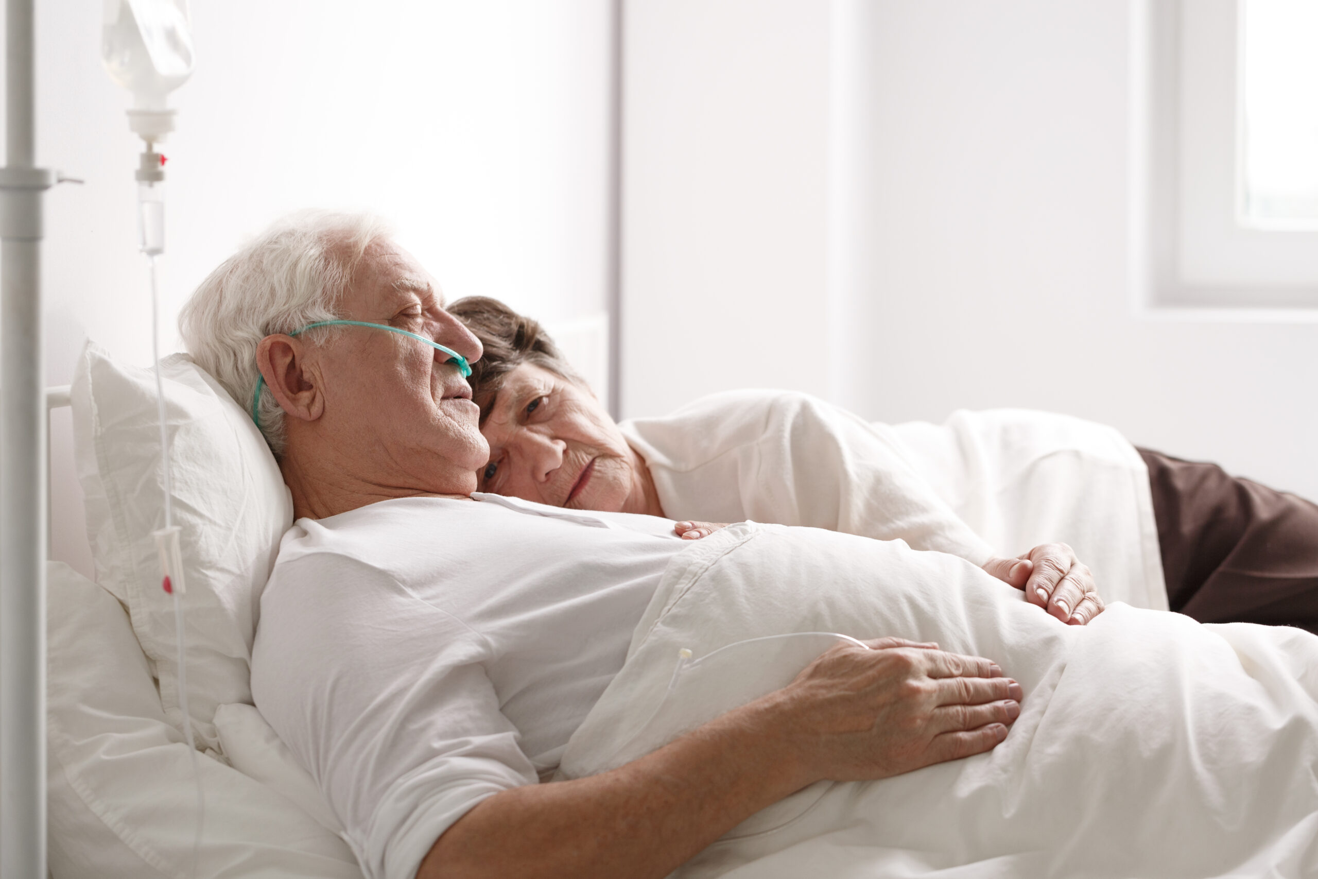 Senior couple on hospital bed Sad senior couple sleeping on hospital bed